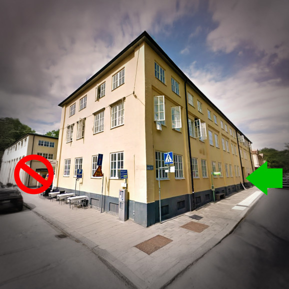bild på fasaden på ABF-huset, med ett kryss över innergården och en grön pil som visar gången in från Storgatan.