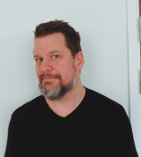 Porträttbild på medarbetaren Rikard mot en neutral bakgrund