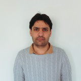 Porträttbild på medarbetaren Usman mot en neutral bakgrund