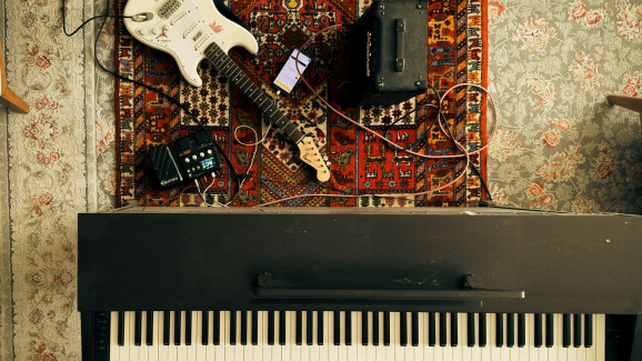 ett piano, förstärkare och elgitarr.