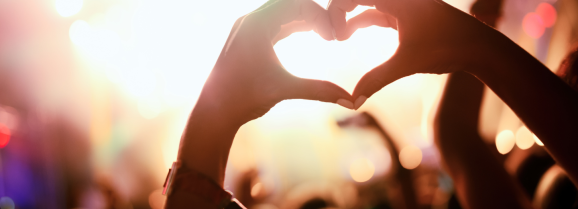 två händer som formar ett hjärta på konsert