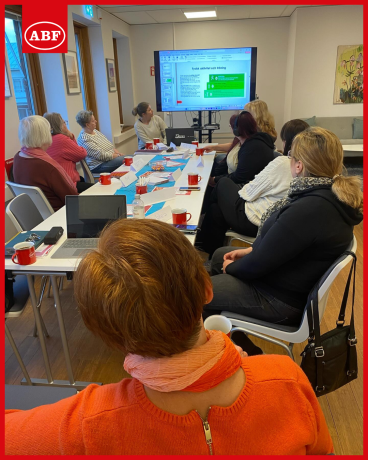 Kvinnor sitter runt ett bort och lyssnar på en föreläsning