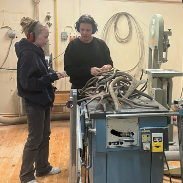 Bild på två som står i en verkstad