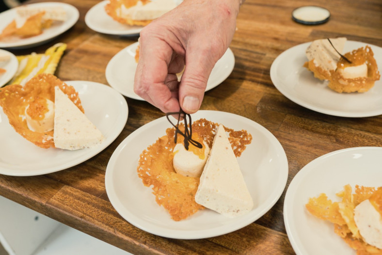 Hand lägger upp dessert på en tallrik