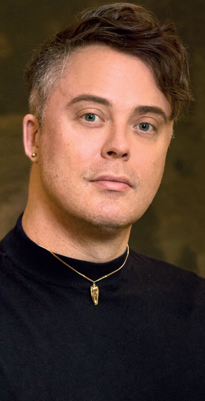 Carl Johan Karlsons porträtt. Närbild, han tittar rakt in i kameran med allvarlig uppsyn.