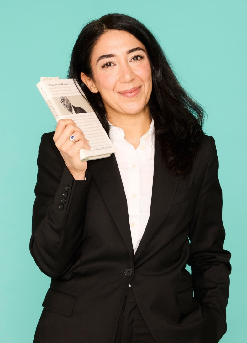 Lawen Redan håller i en bok och ler