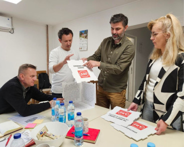 Fyra personer gör Folkbildningsspelet vid ett bord inomhus.