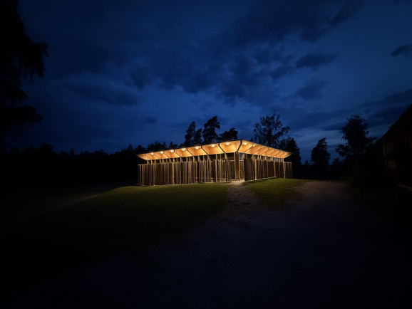 Hegnhuset som omgärdar den gamla samlingslokalen Kafébygget lyser upp i mörkret.