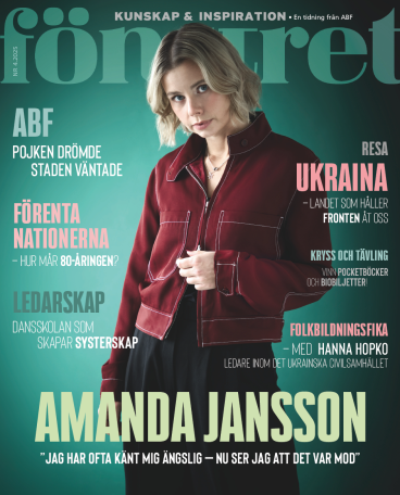 Amanda Jansson pryder omslaget av ABFs kulturmagasin Fönstret. Hon står mot en grön bakgrund i röd jacka och tittar in i kameran.