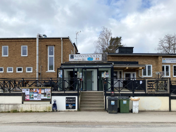 Fasadbild på Konstpoolen med kort trappa upp från gatan och inglasad entré till ABF Södertörns studie- och musiklokaler som är belägna en trappa ner.