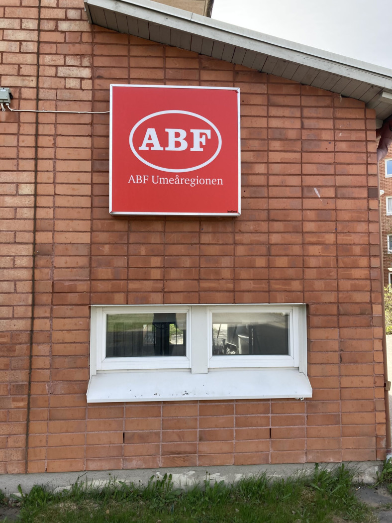 Husfasad till ABF Ersboda. Tegelbyggnad med en röd skylt med ABF loggan och texten ABF Umeåregionen