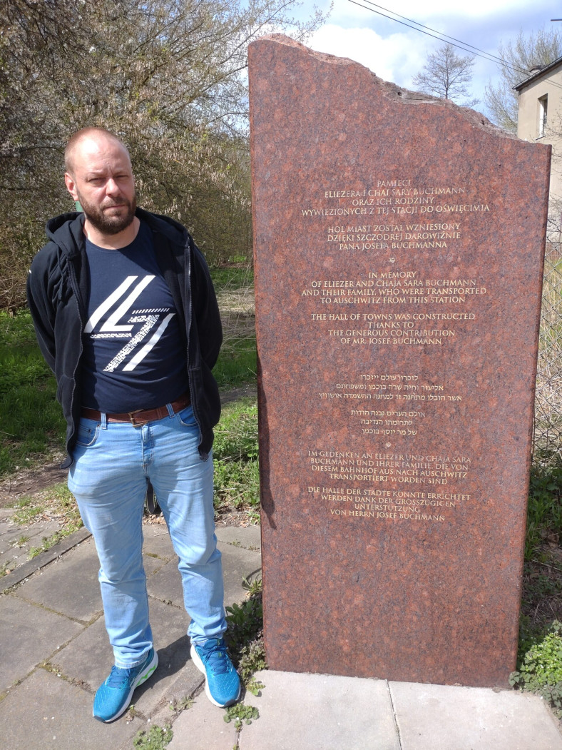 Person som står vid minnessten i Lodz.