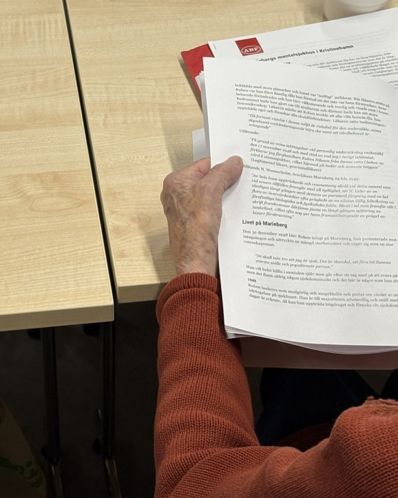 Studiematerial som person håller i sin ena hand.