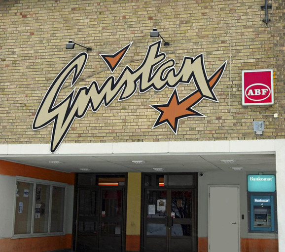 Bild på husvägg med gult tegel och skyltar på ABF och Gnistan